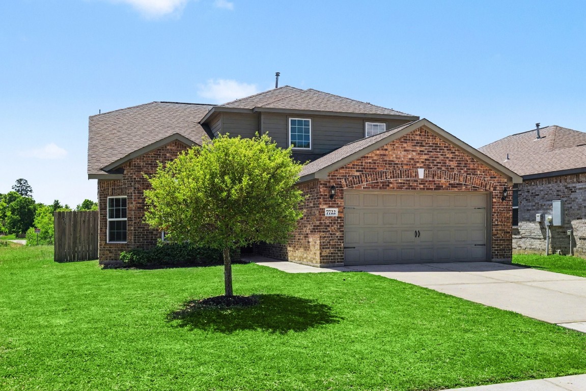 7722 Boulder Sunstone Lane Conroe, TX 77304 - Photo 3 of 25 a front view of a house with a garden