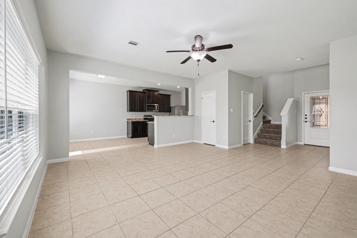 7722 Boulder Sunstone Lane Conroe, TX 77304 - Photo 8 of 25 a view of a livingroom with a flat screen tv wooden floor and a ceiling fan