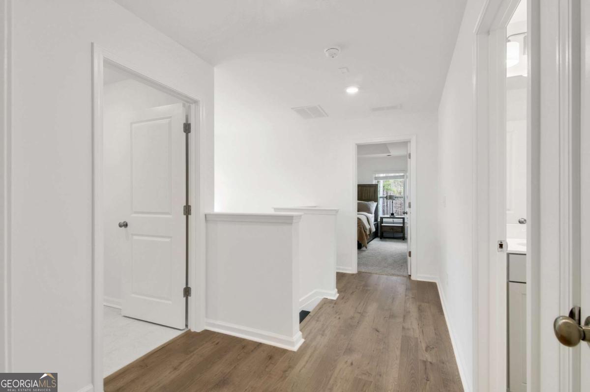 1229 Berwyn Way, Unit 1229 Suwanee, GA 30024 - Photo 14 of 21 a view of a hallway with wooden floor