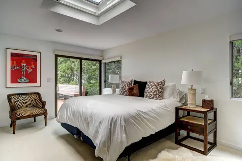 a bedroom with a bed and a couch next to a window