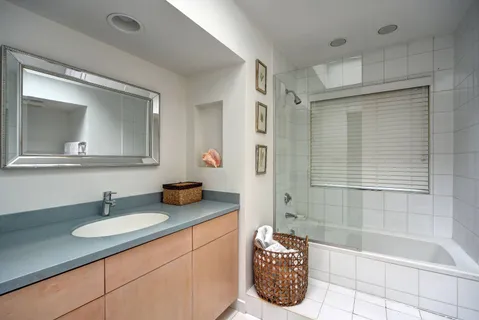 a bathroom with a tub a sink and a mirror
