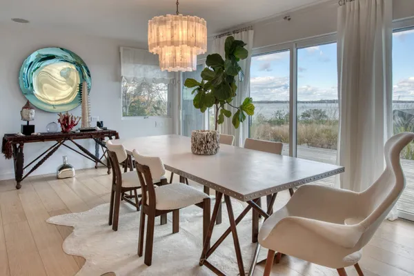 a view of a dining room with furniture a chandelier and wooden floor
