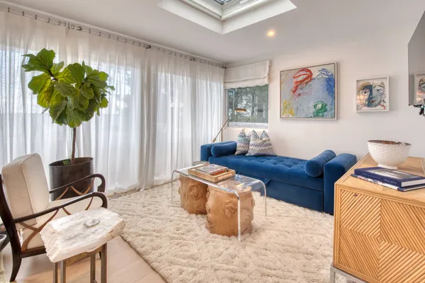 a living room with furniture a couch and a potted plant
