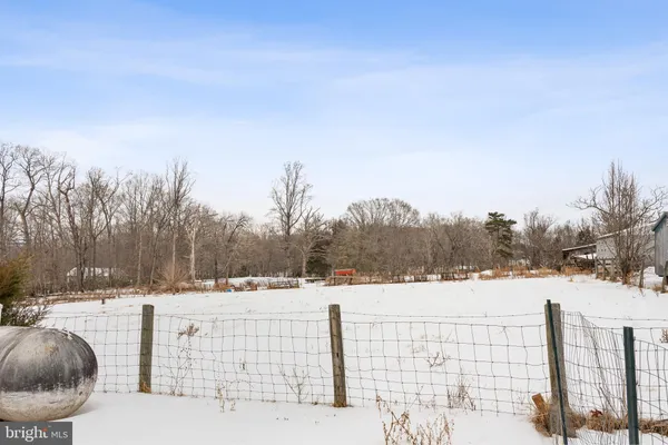 a view of a dry yard with wooden fence