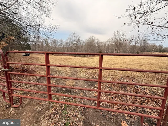 a view of a dry yard with wooden fence