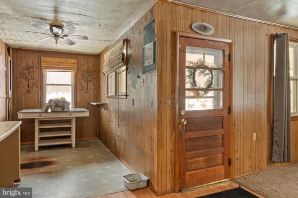 an empty room with wooden floor cabinet and windows