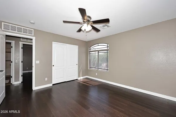 a view of wooden floor and a chandelier fan in a room