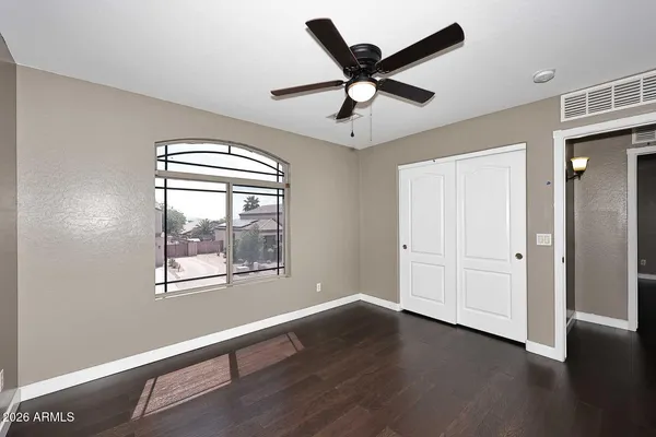 a view of a big room with wooden floor and windows