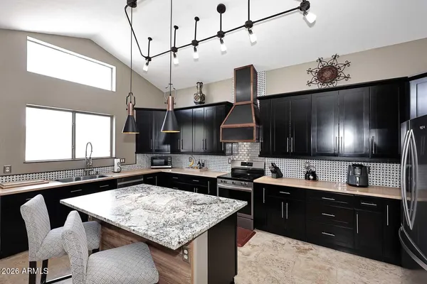 a kitchen with a sink a counter and chairs