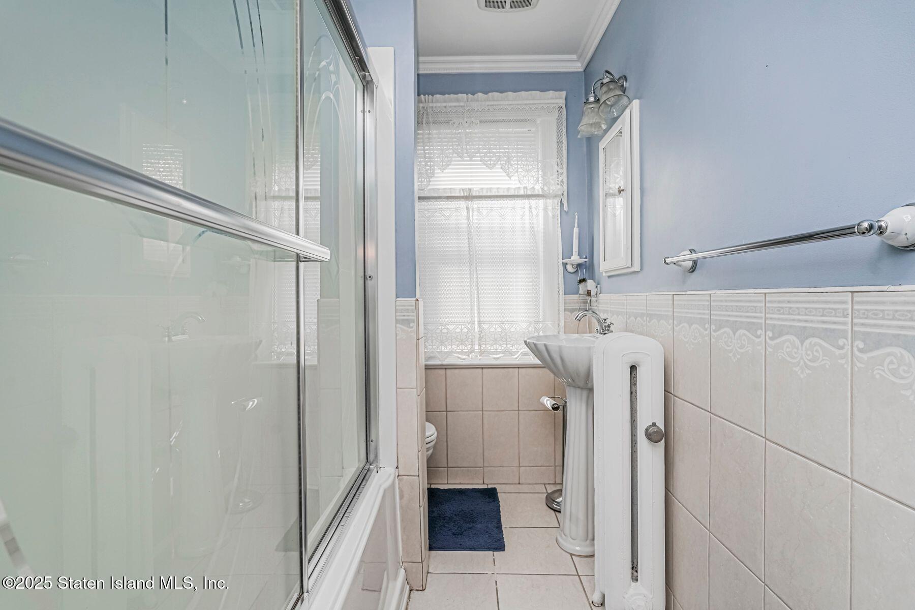 5300 Amboy Road Staten Island, NY 10312 - Photo 22 of 32 a bathroom with a sink a mirror and a shower