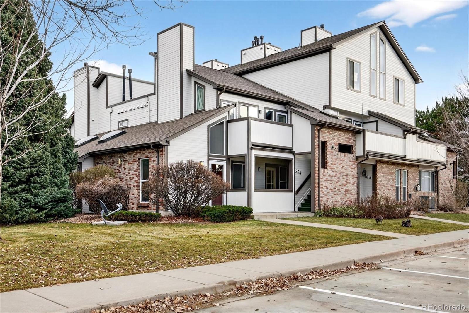 5021 Garrison Street, Unit 103A Wheat Ridge, CO 80033 - Photo 2 of 19 a front view of a house with a yard