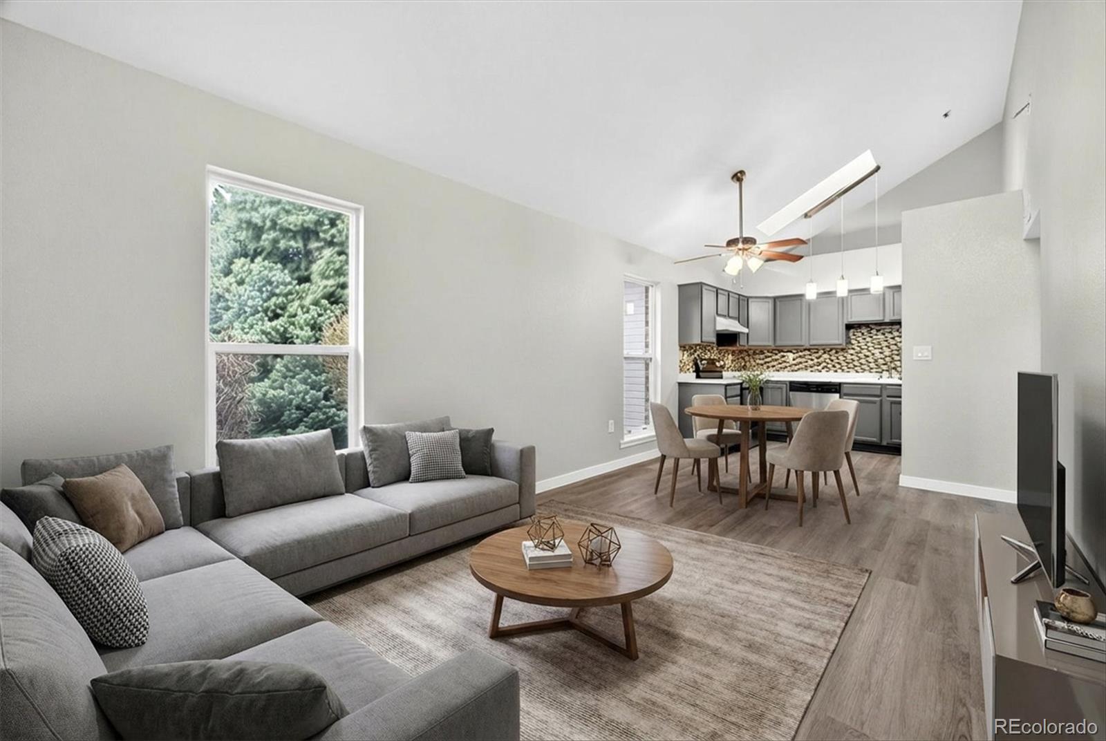 5021 Garrison Street, Unit 103A Wheat Ridge, CO 80033 - Photo 3 of 19 a living room with furniture and a dining table with kitchen view