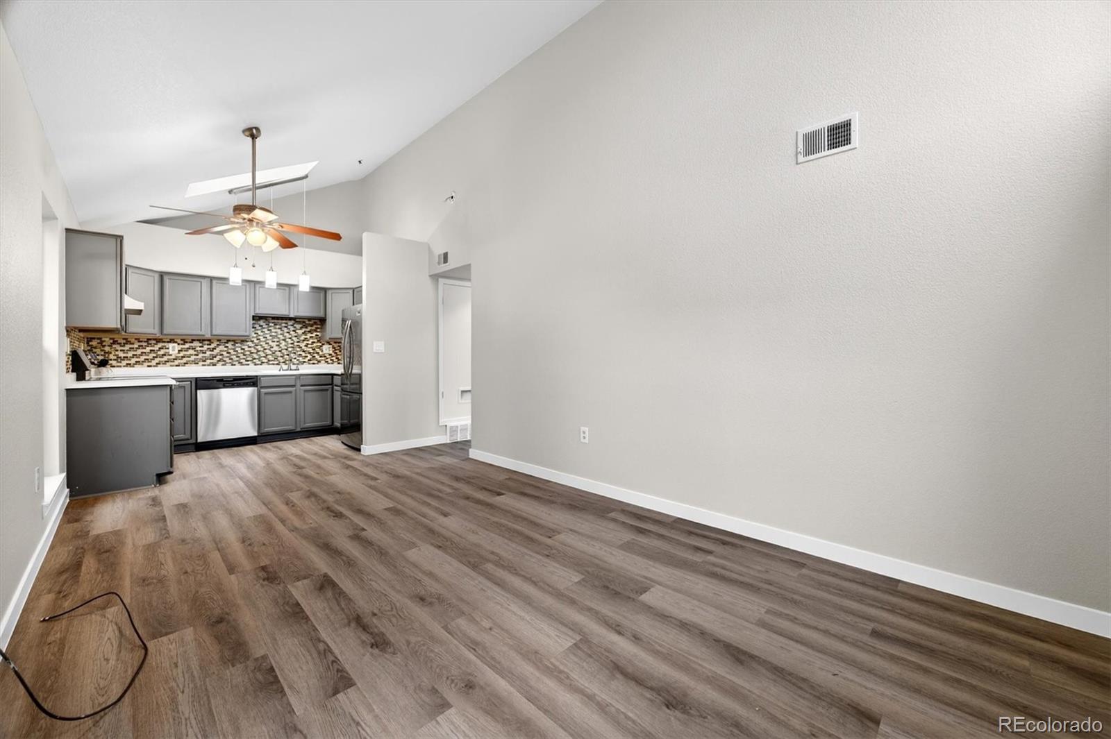 5021 Garrison Street, Unit 103A Wheat Ridge, CO 80033 - Photo 4 of 19 a kitchen with granite countertop a stove and a refrigerator