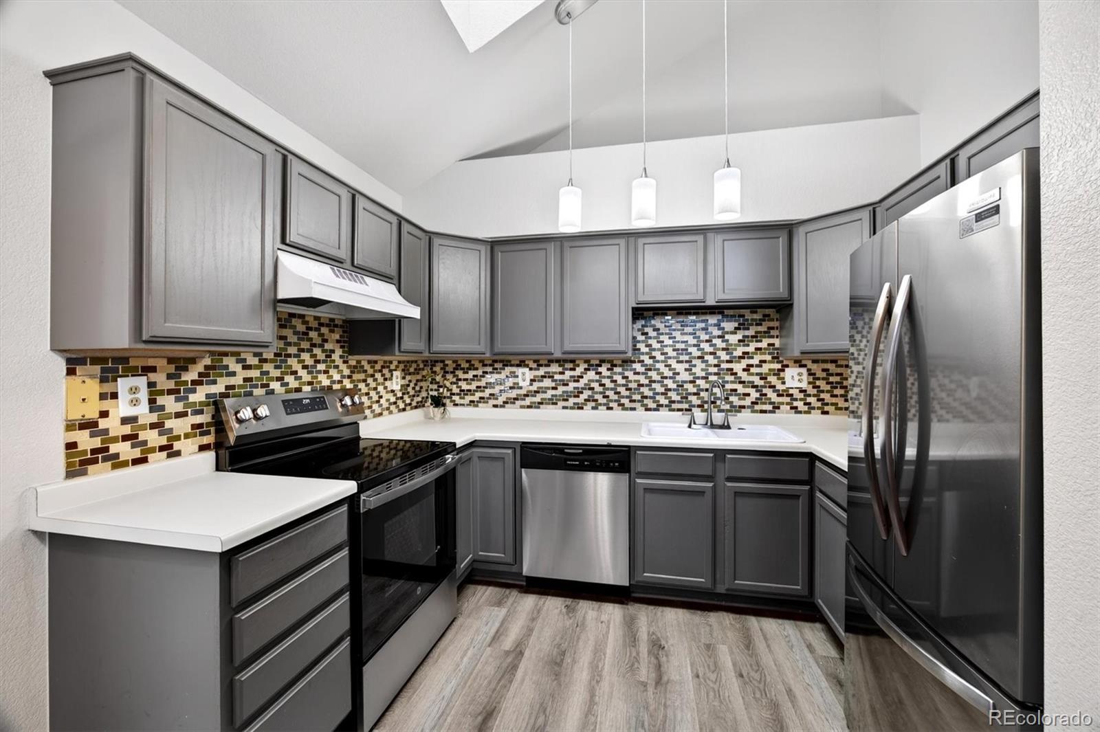 5021 Garrison Street, Unit 103A Wheat Ridge, CO 80033 - Photo 8 of 19 a kitchen with stainless steel appliances a sink stove and refrigerator