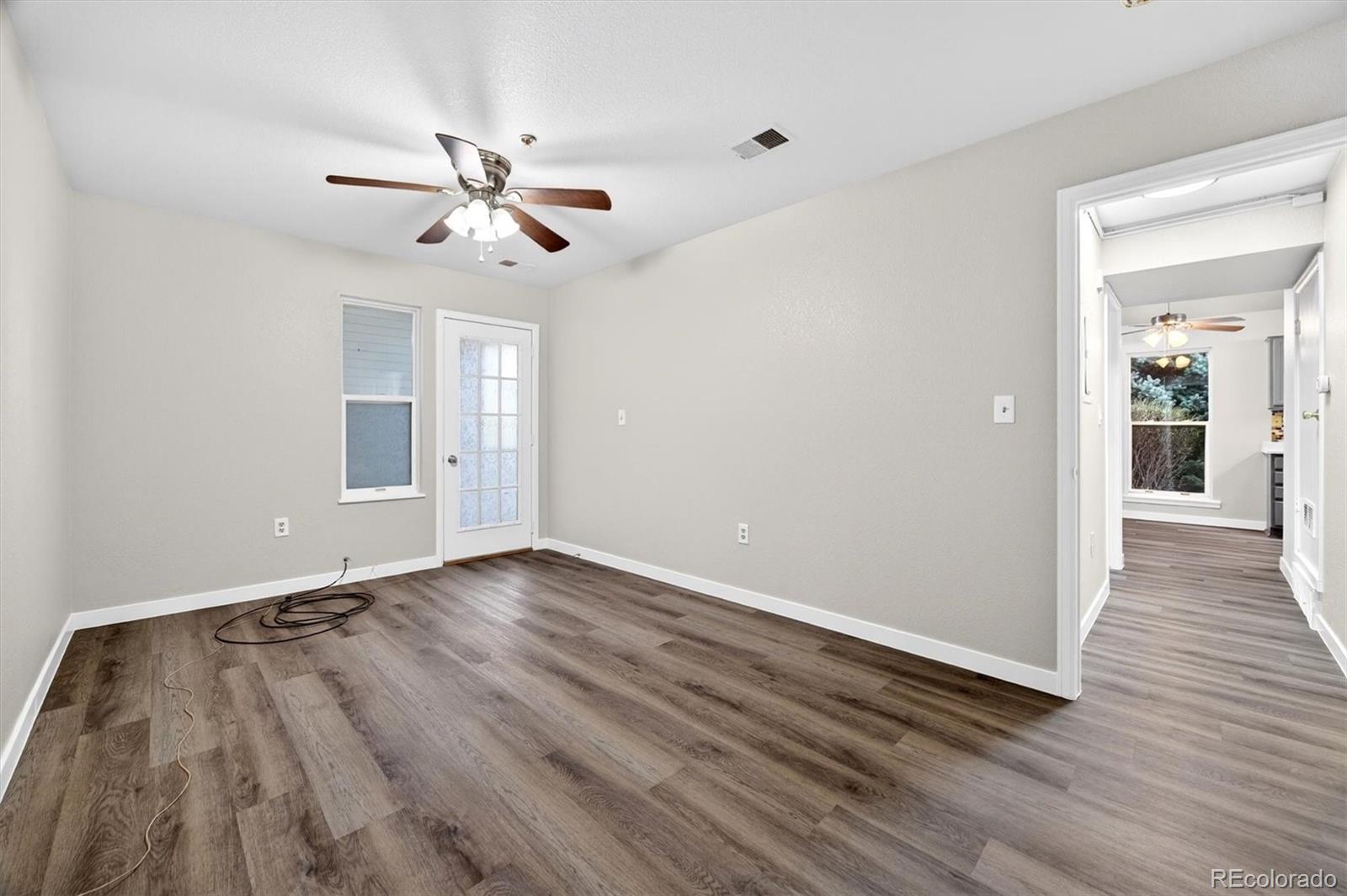 5021 Garrison Street, Unit 103A Wheat Ridge, CO 80033 - Photo 10 of 19 wooden floor in an empty room with a window