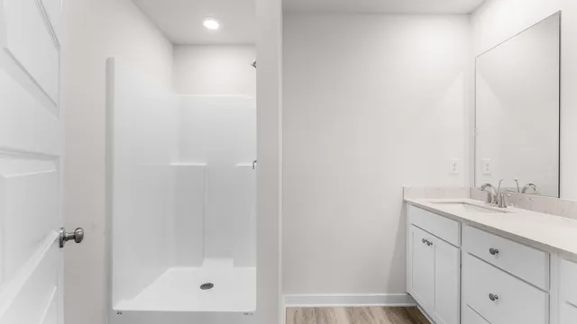 a bathroom with a granite countertop sink a mirror and a shower