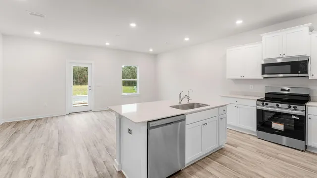 a kitchen with a sink a microwave and cabinets