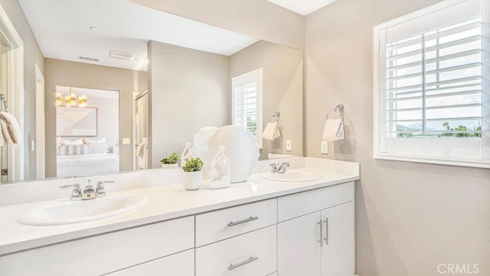 7498 Olive Grv Street Riverside, CA 92507 - Photo 7 of 14 a bathroom with double vanity sinks a mirror and a shower