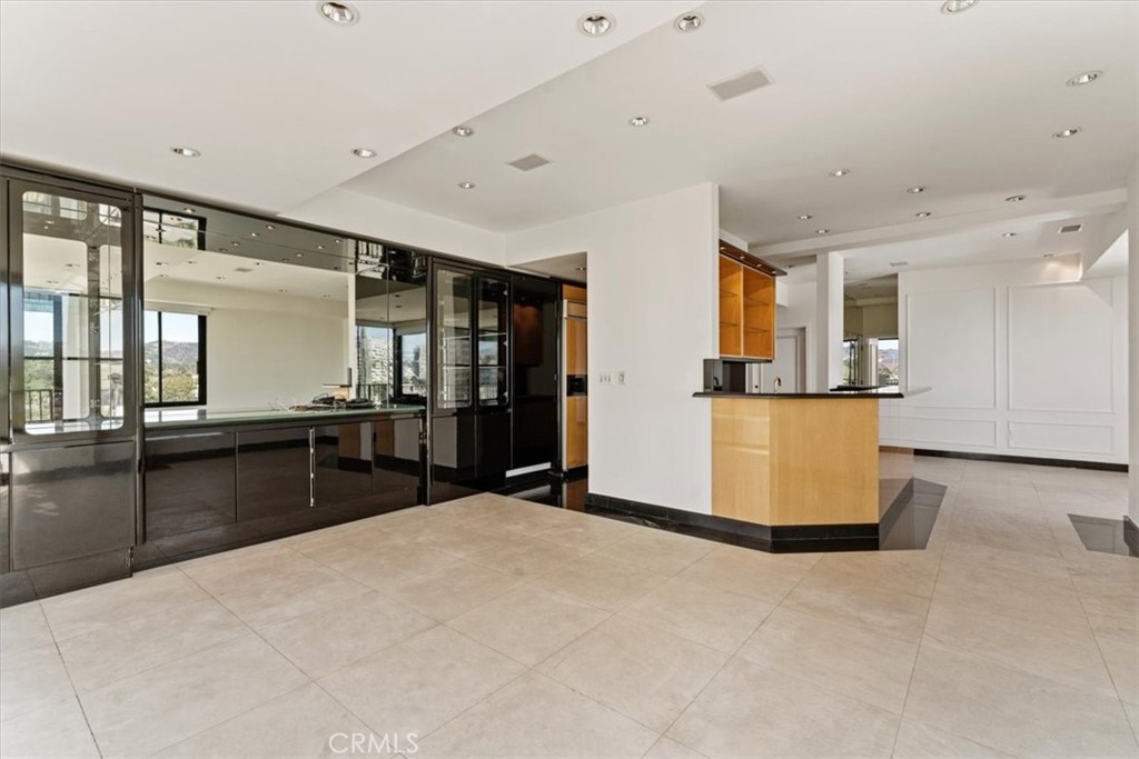 10501 Wilshire Boulevard, Unit 1103 Los Angeles, CA 90024 - Photo 13 of 34 a kitchen with stainless steel appliances kitchen island granite countertop a refrigerator and cabinets