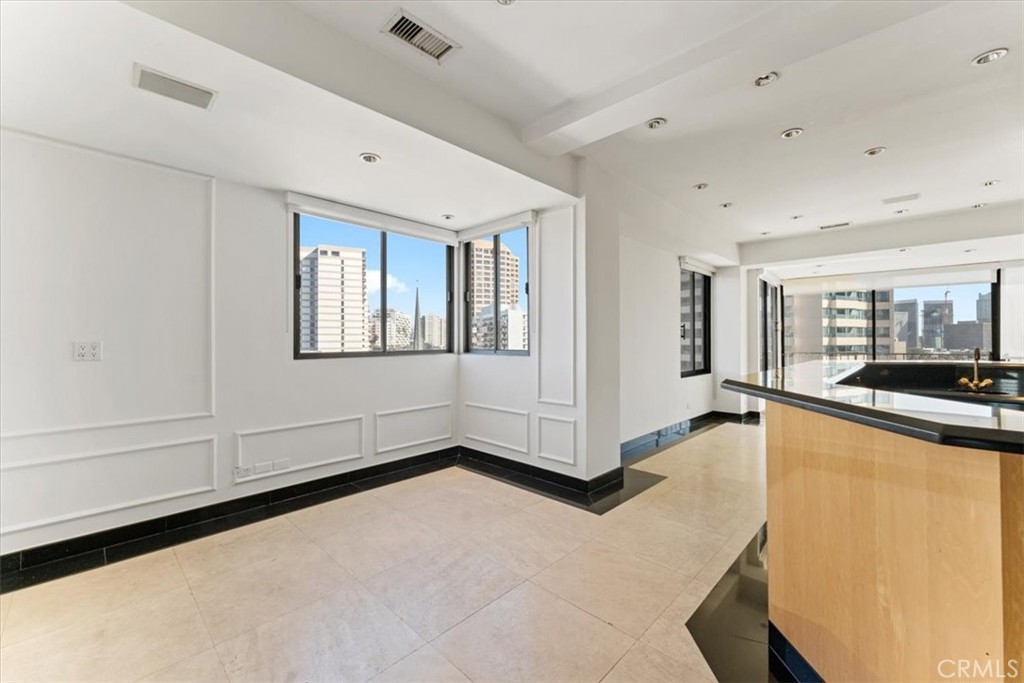 10501 Wilshire Boulevard, Unit 1103 Los Angeles, CA 90024 - Photo 6 of 34 a view of a livingroom with wooden floor and white walls