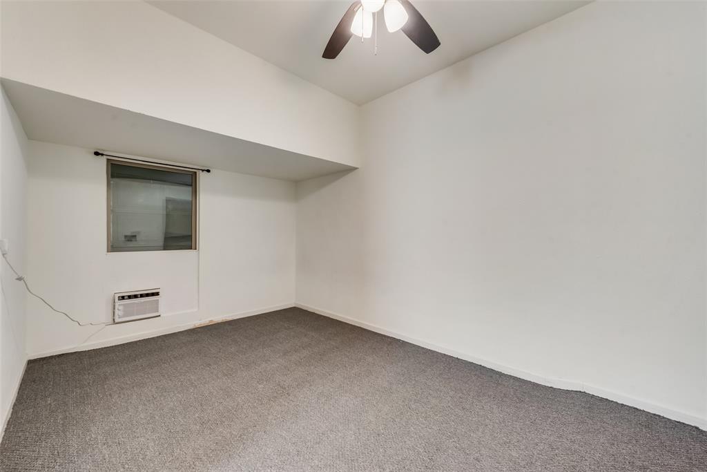4517 Raleigh Dalton Road Dallas, TX 75227 - Photo 18 of 20 an empty room with a ceiling fan and windows