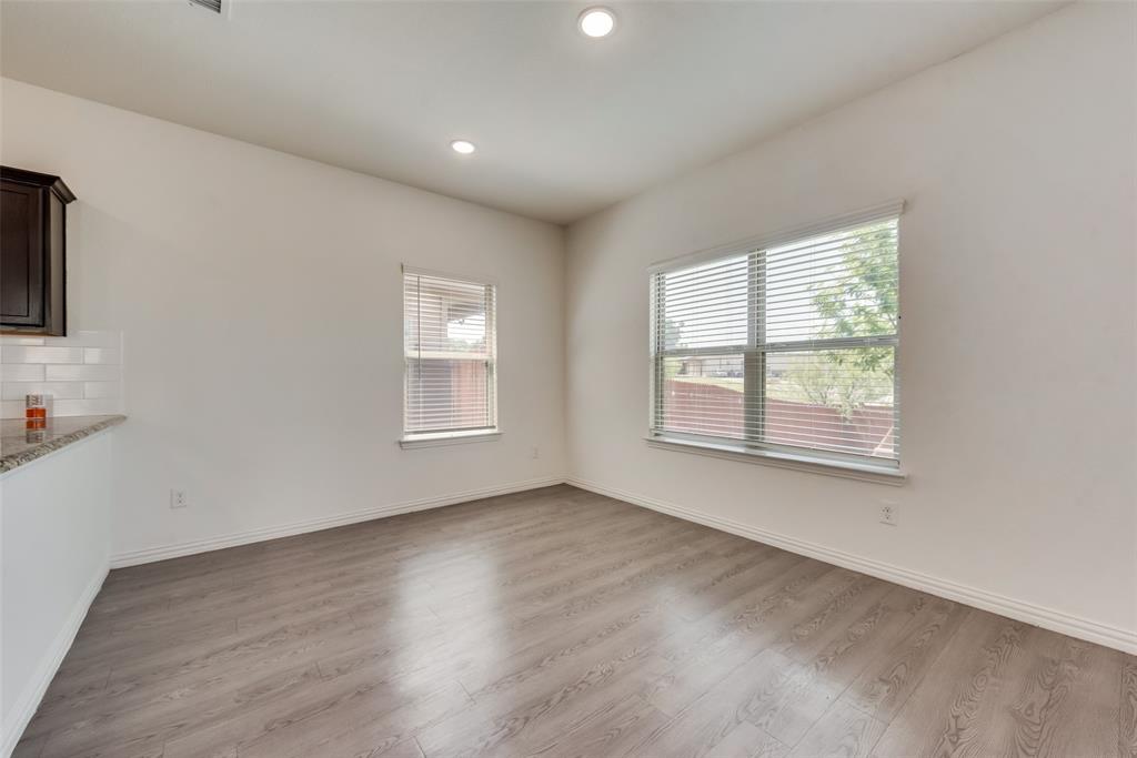 4517 Raleigh Dalton Road Dallas, TX 75227 - Photo 6 of 20 a view of an empty room with wooden floor and a window