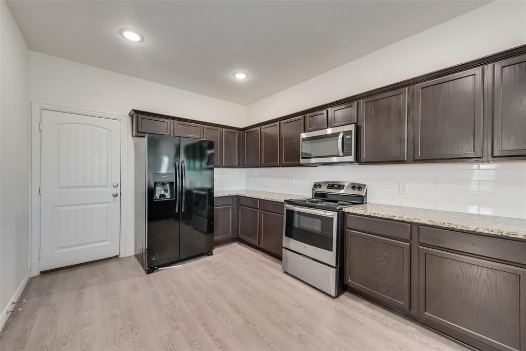 4517 Raleigh Dalton Road Dallas, TX 75227 - Photo 7 of 20 a kitchen with stainless steel appliances granite countertop a refrigerator stove and sink