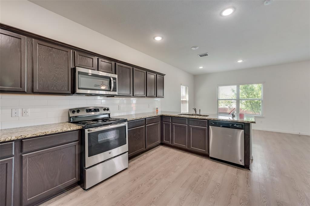 4517 Raleigh Dalton Road Dallas, TX 75227 - Photo 8 of 20 a kitchen with stainless steel appliances granite countertop a stove a sink and a microwave