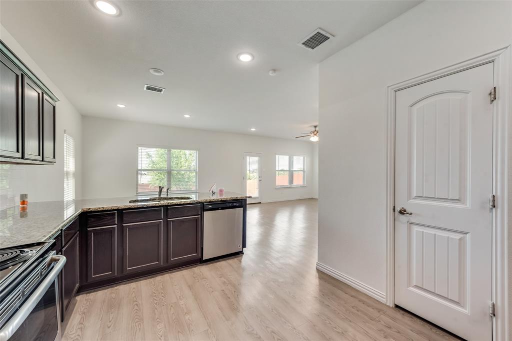 4517 Raleigh Dalton Road Dallas, TX 75227 - Photo 9 of 20 a large kitchen with stainless steel appliances granite countertop a sink and dishwasher with wooden floor