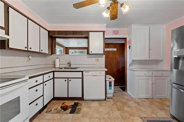 a kitchen with white cabinets and refrigerator