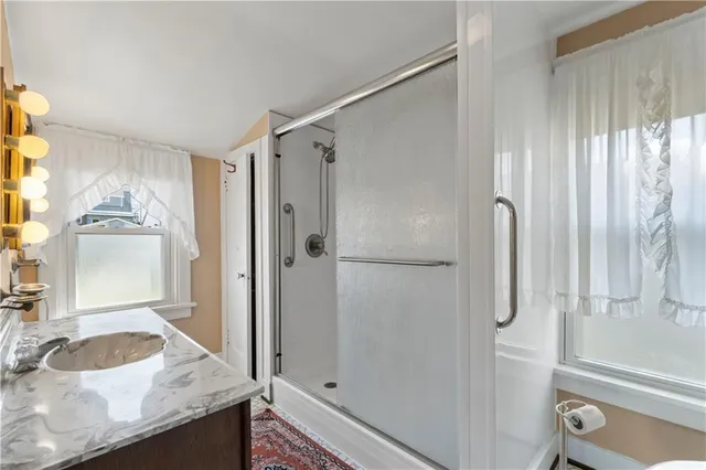 a bathroom with a granite countertop sink toilet and shower