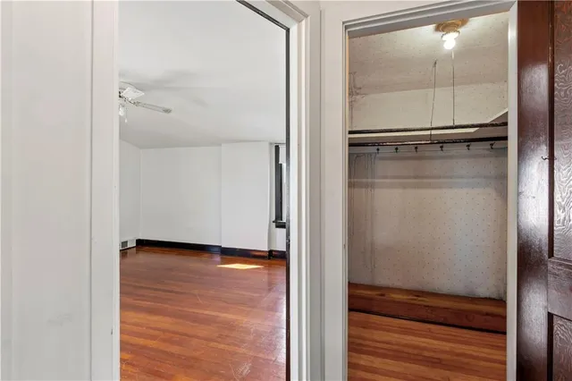 a view of empty room with wooden floor and cabinet