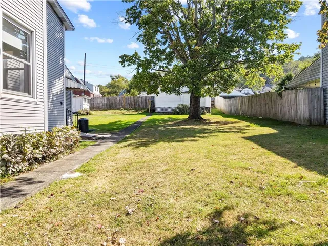 a swimming pool with yard and wooden fence