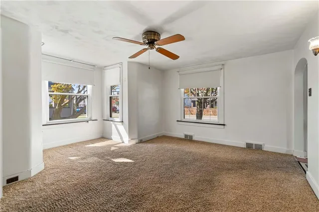 a view of an empty room with window and cabinet