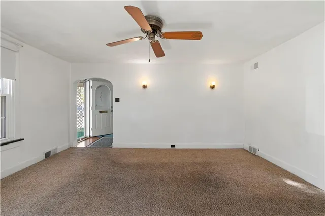 an empty room with closet and windows