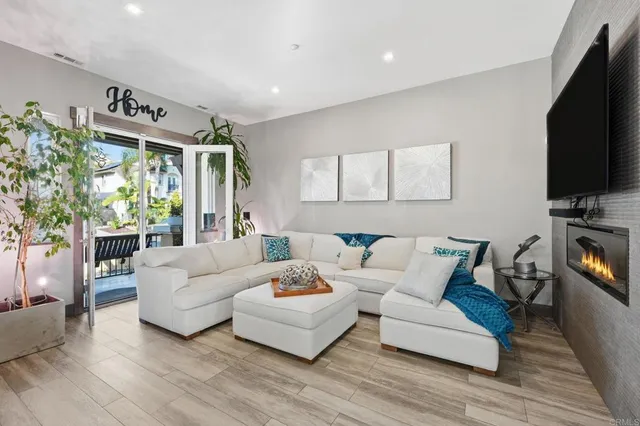 a living room with furniture flat screen tv and a large window