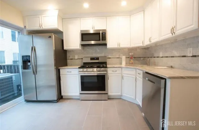 a kitchen with stainless steel appliances granite countertop a refrigerator stove a sink and dishwasher