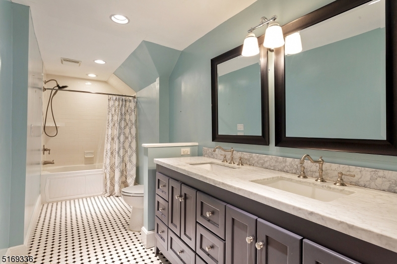 62 Crane Street Caldwell, NJ 07006 - Photo 15 of 28 a bathroom with a double vanity sink a mirror and a bathtub