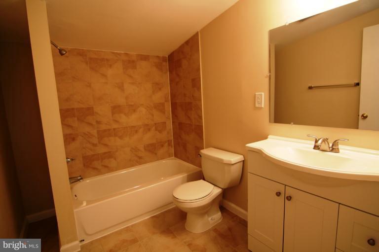 2038 Rolling Rd. Windsor Mill, MD 21244 - Photo 4 of 16 a bathroom with a toilet a sink and a bathtub