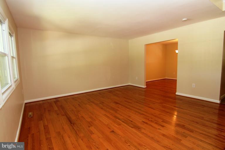 2038 Rolling Rd. Windsor Mill, MD 21244 - Photo 5 of 16 an empty room with wooden floor and windows
