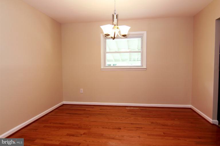 2038 Rolling Rd. Windsor Mill, MD 21244 - Photo 8 of 16 a view of an empty room with wooden floor and a window