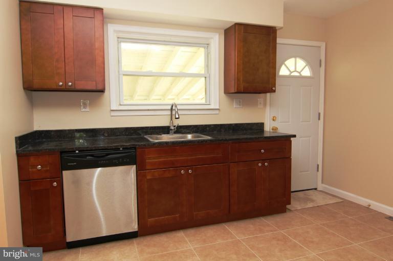 2038 Rolling Rd. Windsor Mill, MD 21244 - Photo 10 of 16 a kitchen with granite countertop a sink and a stove