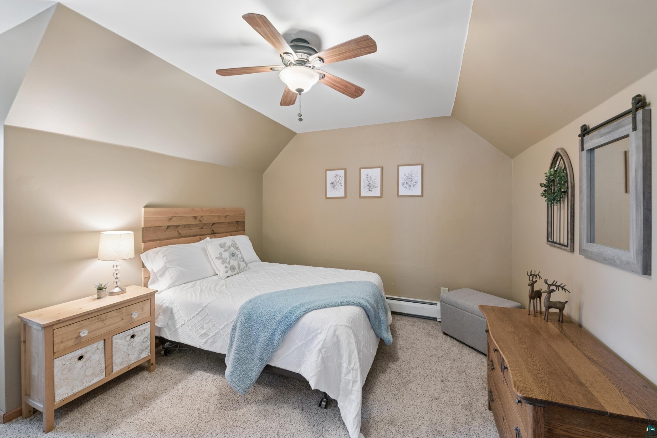 3113 Golf Course Road Ashland, WI 54806 - Photo 24 of 38 Carpeted room featuring a ceiling fan with light fixture, vaulted ceiling, and baseboard heating