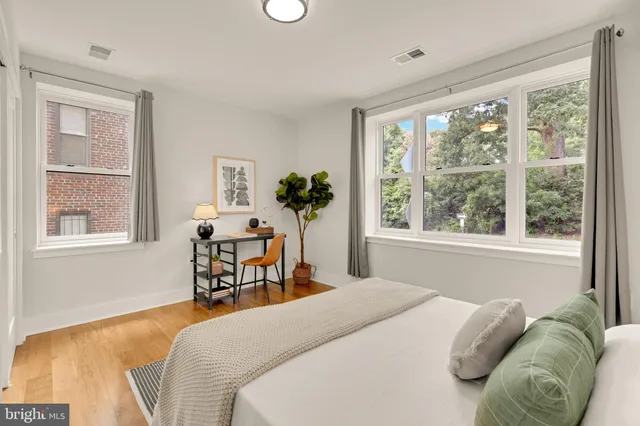 a bedroom with a bed and a large window