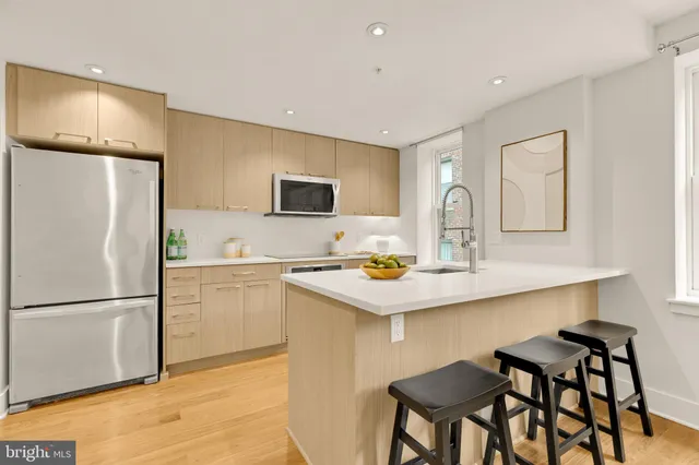 a kitchen with a dining table chairs refrigerator and cabinets