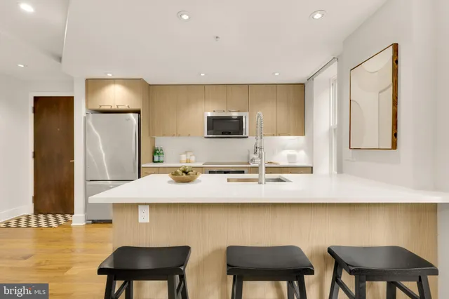 a kitchen with a sink cabinets and chair
