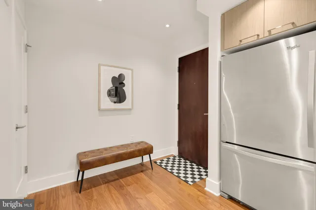a walk in closet with wooden floor