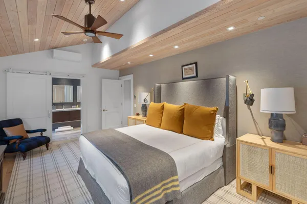 a dining hall with stainless steel appliances kitchen island granite countertop a table chairs and a wooden floor