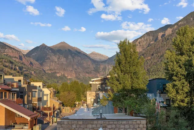 a large kitchen with stainless steel appliances granite countertop a stove and a wooden floors