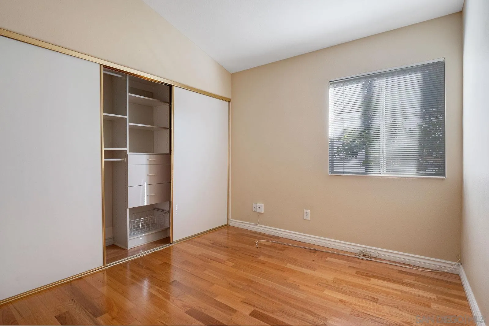 5512 Renaissance Avenue, Unit 3 San Diego, CA 92122 - Photo 32 of 57 an empty room with wooden floor and windows